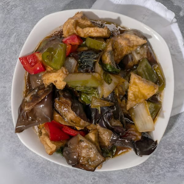 Vietnamese stir-fried eggplant and tofu with red and green bell peppers in a savory sauce.